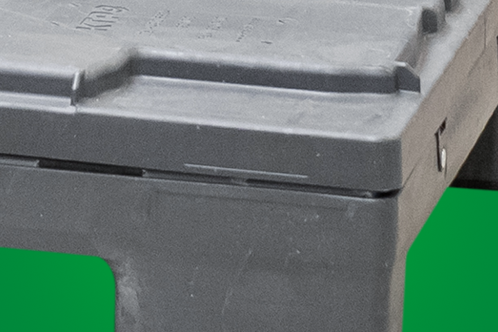 Close-up of a gray plastic storage container with a lid, showing a seam and textured surface.