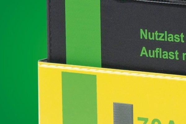 Close-up of a brightly colored packaging with black and yellow sections, featuring text in German that reads "Nutzlast" and "Auflast."