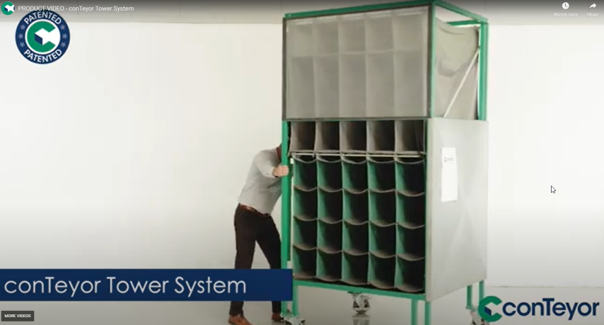 A person operates the conTeyor Tower System, a storage unit with multiple compartments, on wheels against a white background.