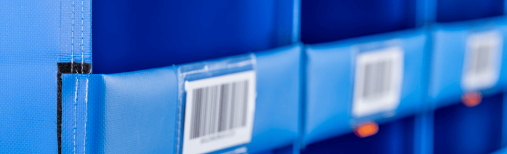 Close-up of blue storage containers with visible barcodes attached.