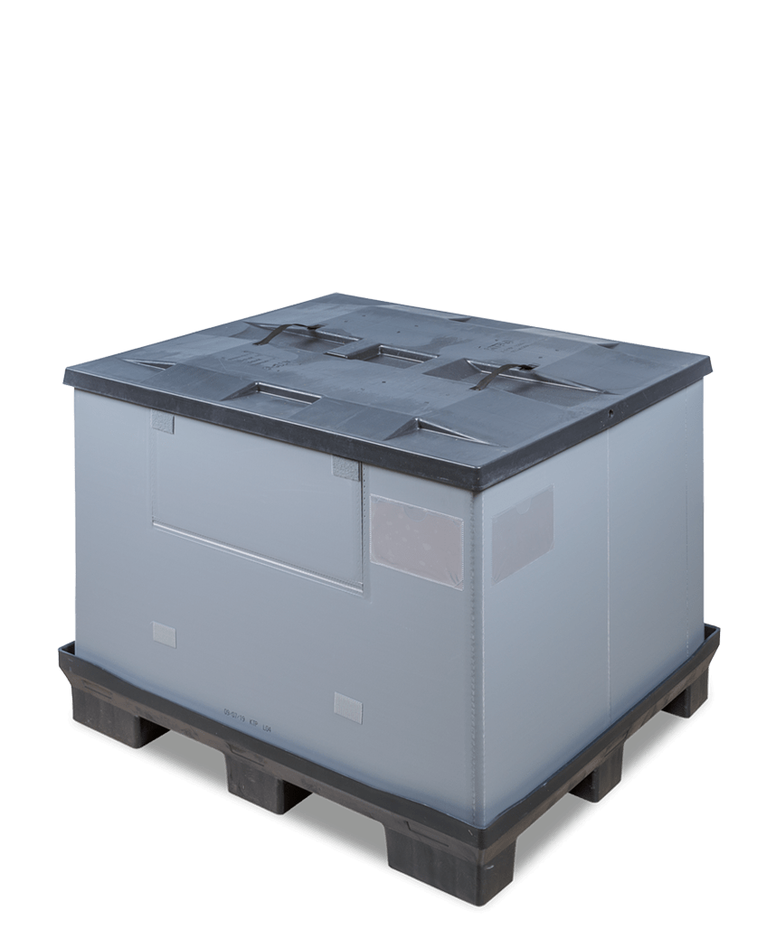 A square, stackable plastic container with a black lid, sitting on a black pallet, featuring various openings and labels on its sides.