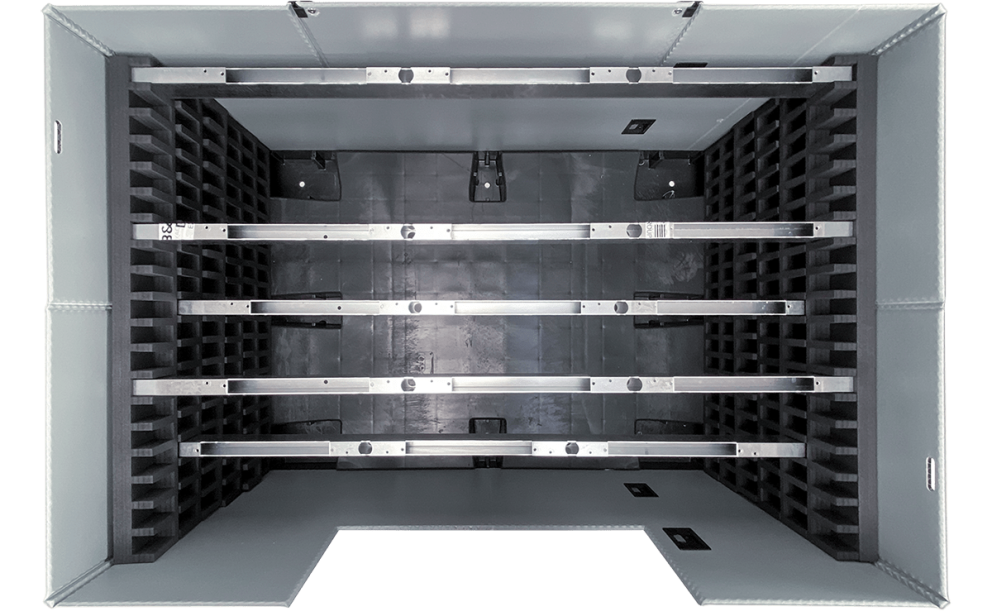 An overhead view of a rectangular grey storage container with multiple black foam dividers and metal rails inside.