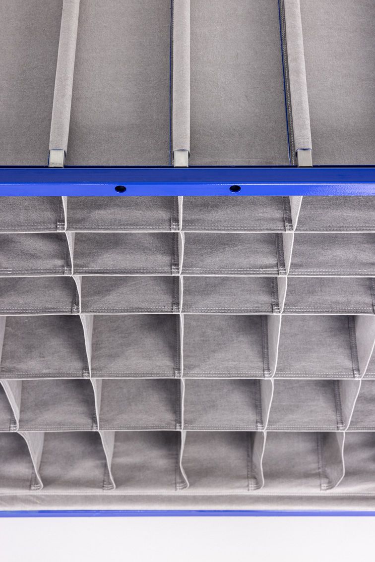 A close-up of a blue modular rack with textile inserts