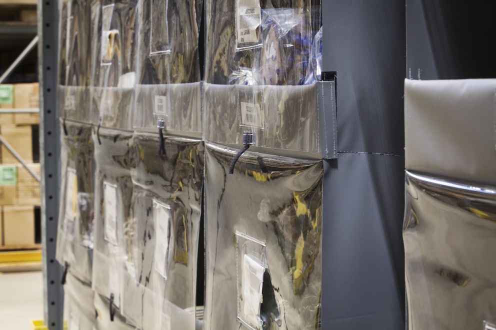 A close-up of a Storeganizer installation for H.Essers in a large warehouse with yelllow accents and front-stoppers