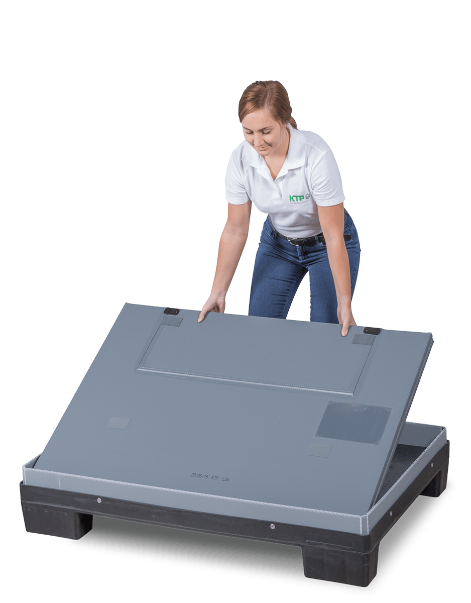 A woman in a white shirt is lifting the lid of a large gray container, demonstrating its use.