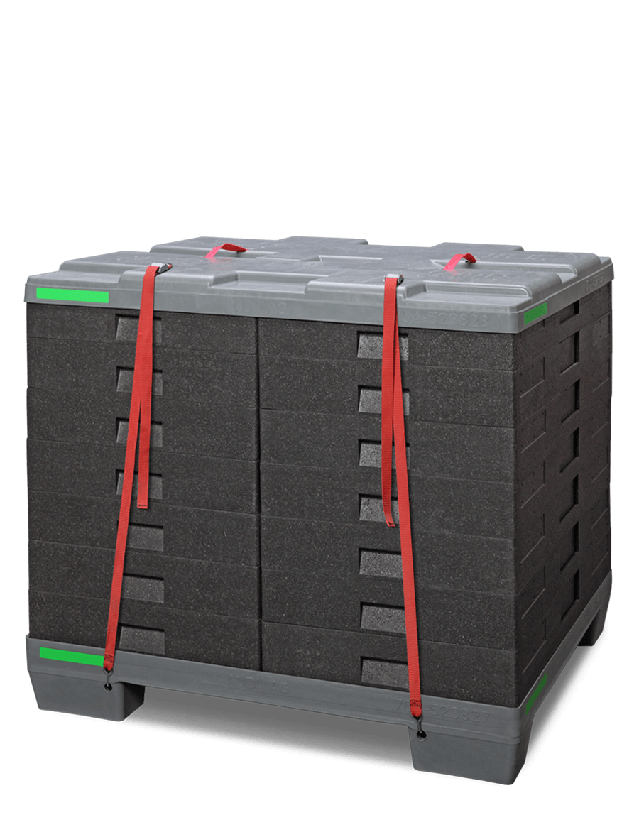 A stack of black foam blocks secured with red straps on a gray base.