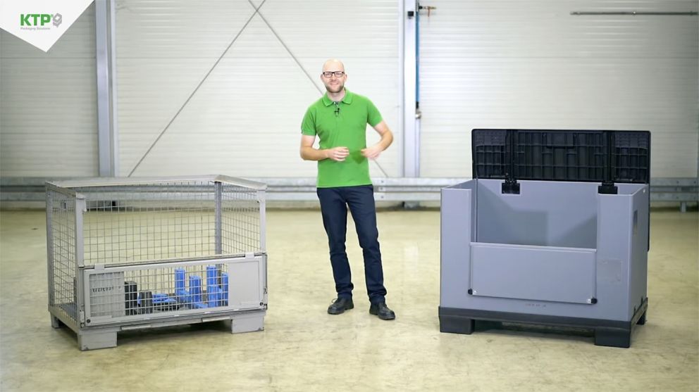 A man in a green shirt stands between two types of storage containers: a metal wire cage on the left and a plastic bin with a lid on the right, in an industrial setting.