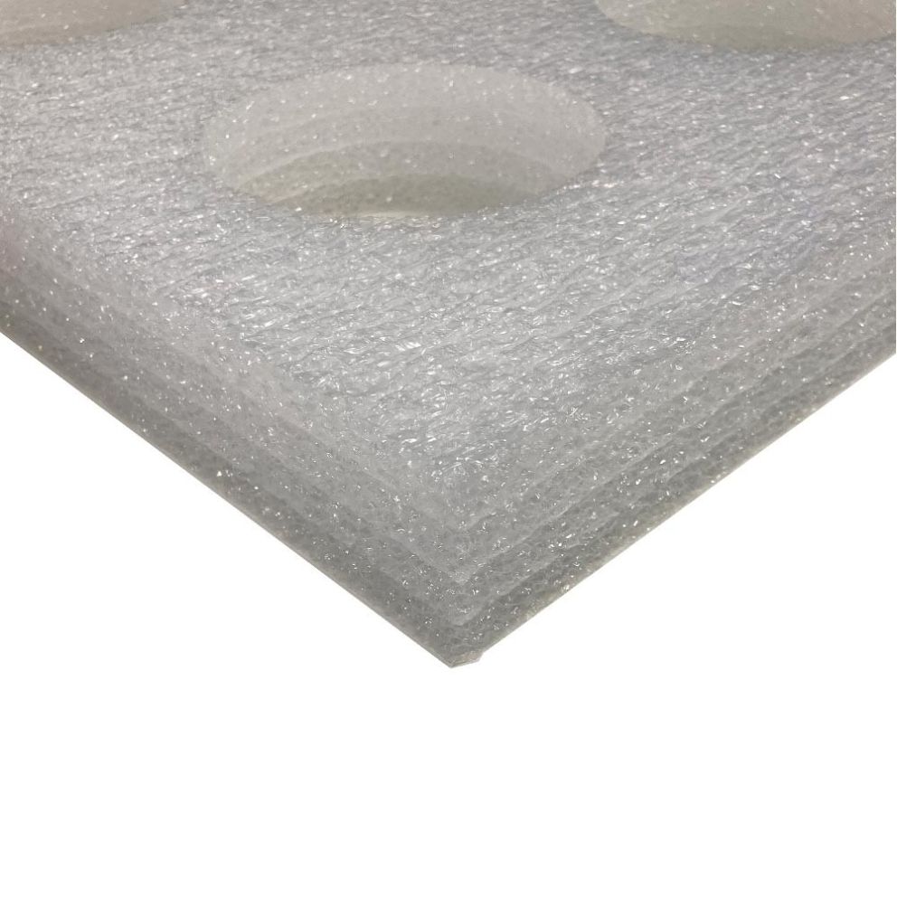 A close-up view of a white foam board with circular cutouts, stacked in layers.
