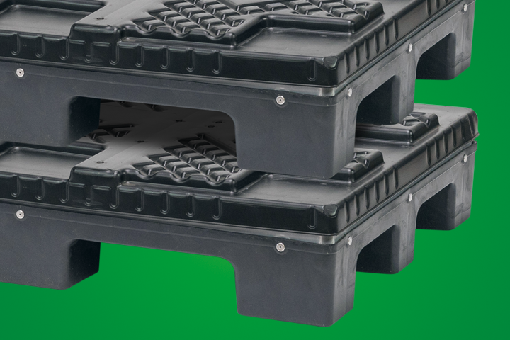 Two stacked black plastic pallets on a green background.