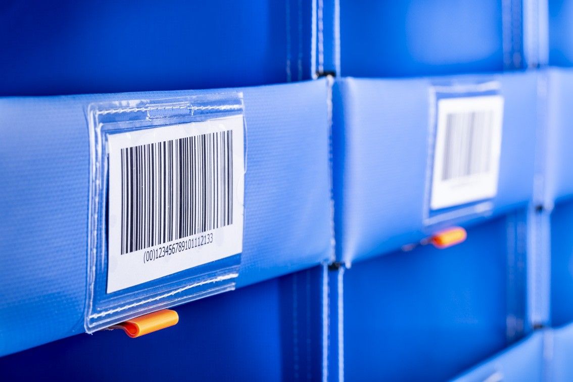 Close-up of blue storage containers with barcode labels attached.