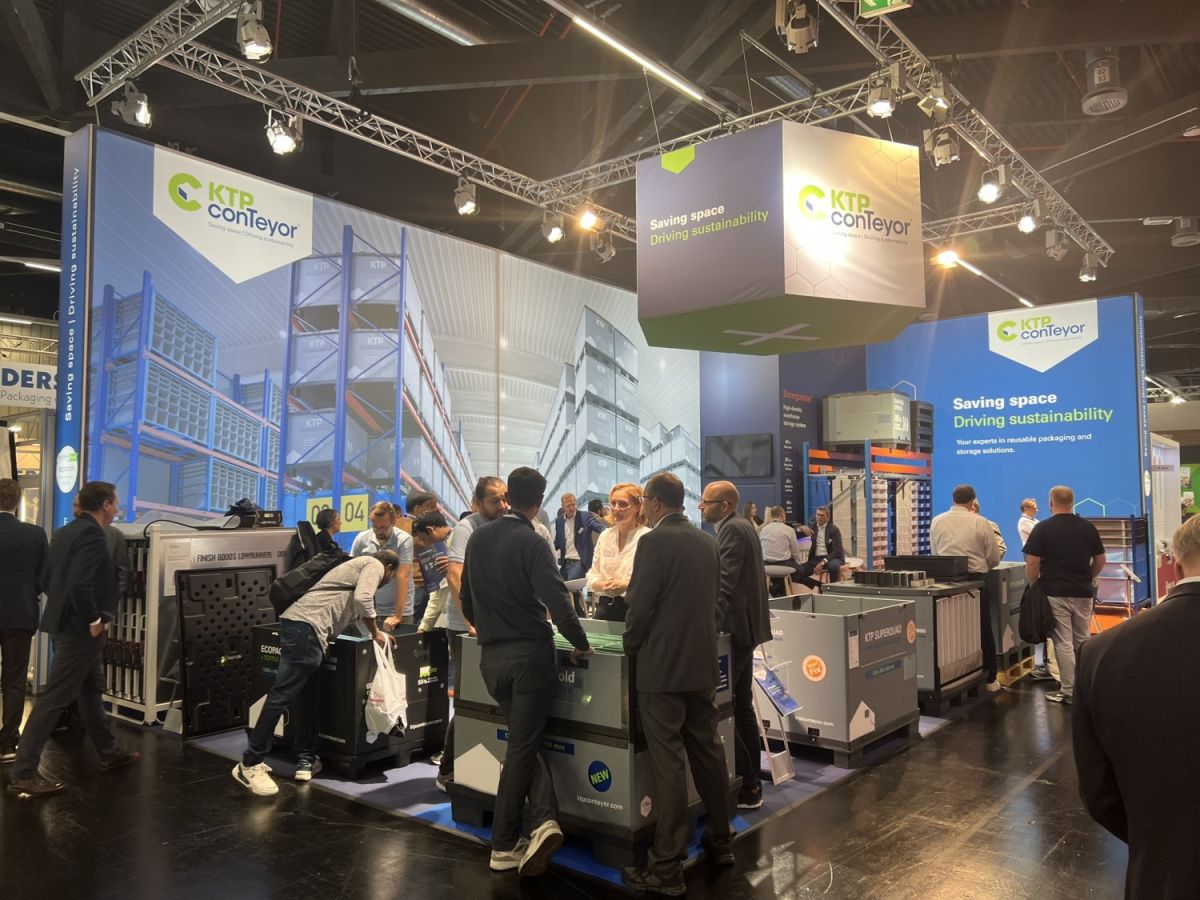 A busy trade show booth for KTP ConTeyor featuring promotional banners, product displays, and attendees engaging with representatives.