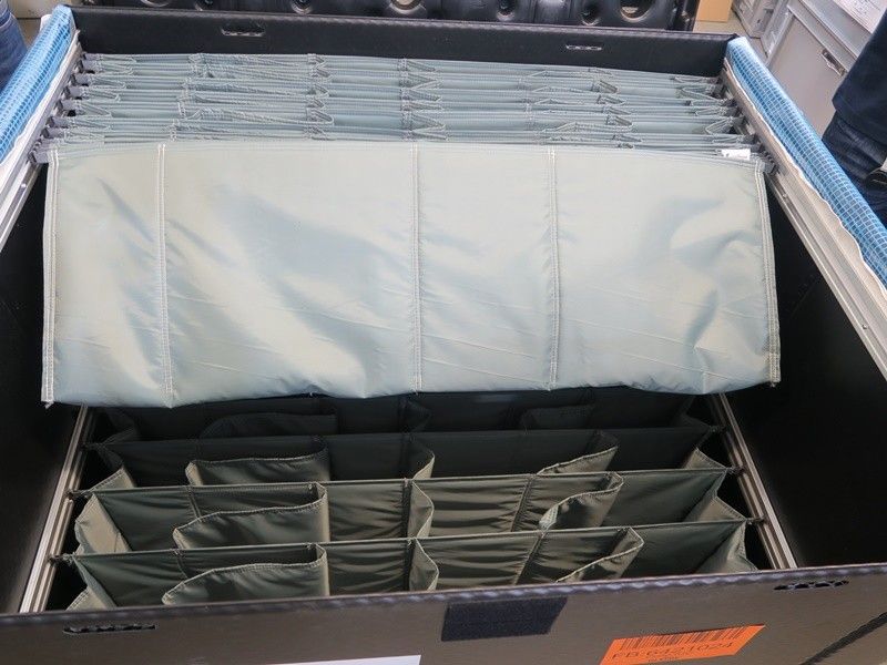 A black container filled with green fabric folders organized in rows.