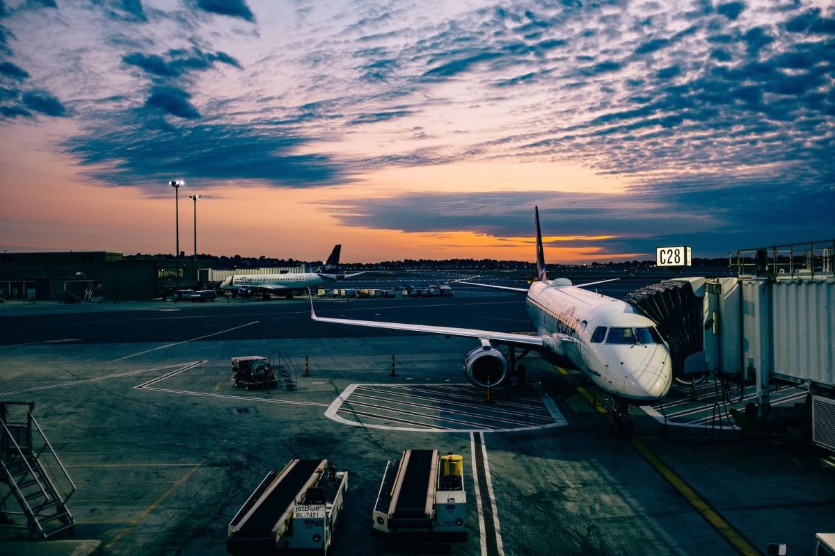 A plane docked at an airport with a dark sky above