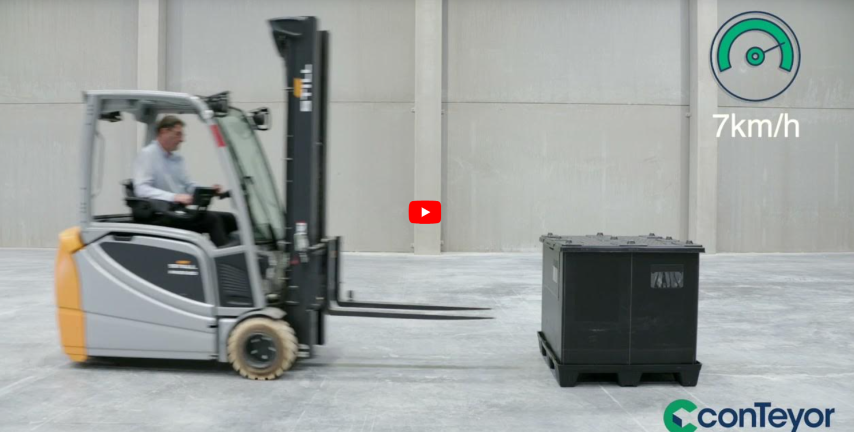 A forklift moving towards a black container in an empty warehouse, with a speed indicator showing 7 km/h.