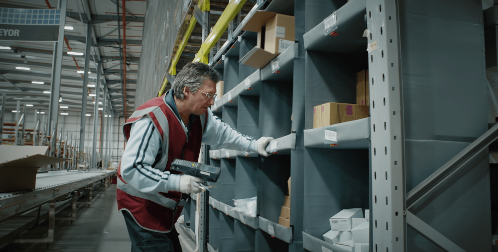 A person picking orders out of a storeganizer installation