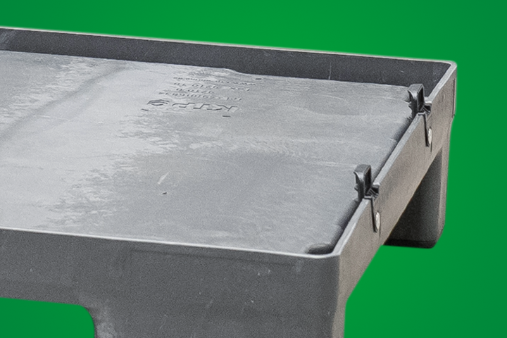 A close-up of a gray plastic container with latches on a green background.