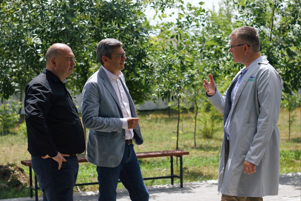 conTeyor's CEO Orm, talking with two other people in a garden