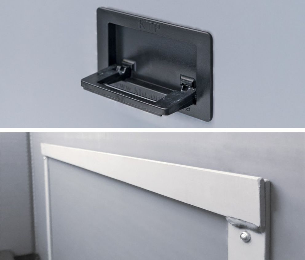 Close-up of a black plastic handle on a gray background and a metal frame with a light gray edge.