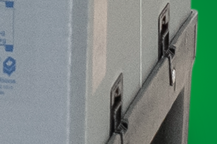 Close-up of a grey storage container with visible clasps and a green background.
