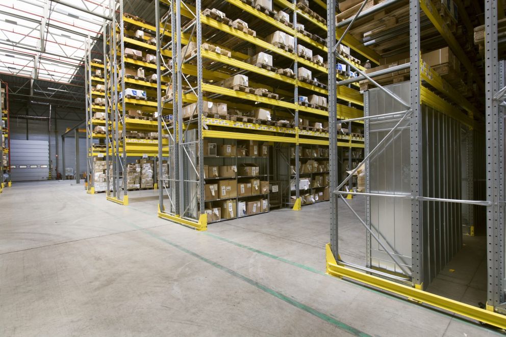 A close-up of a Storeganizer installation for H.Essers in a large warehouse with yelllow accents and front-stoppers