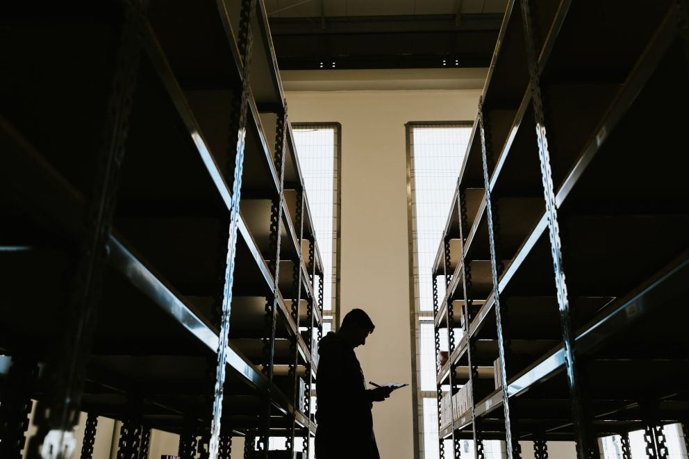A man standing between two racks in a warehouse