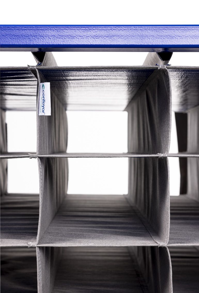 A close-up of a blue modular rack with textile inserts