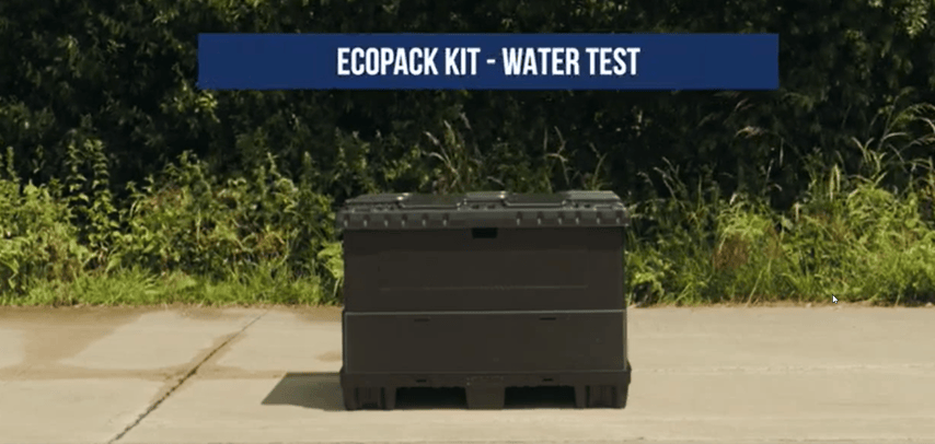 A black rectangular container labeled "ECOpack Kit - Water Test" on a concrete surface with greenery in the background.