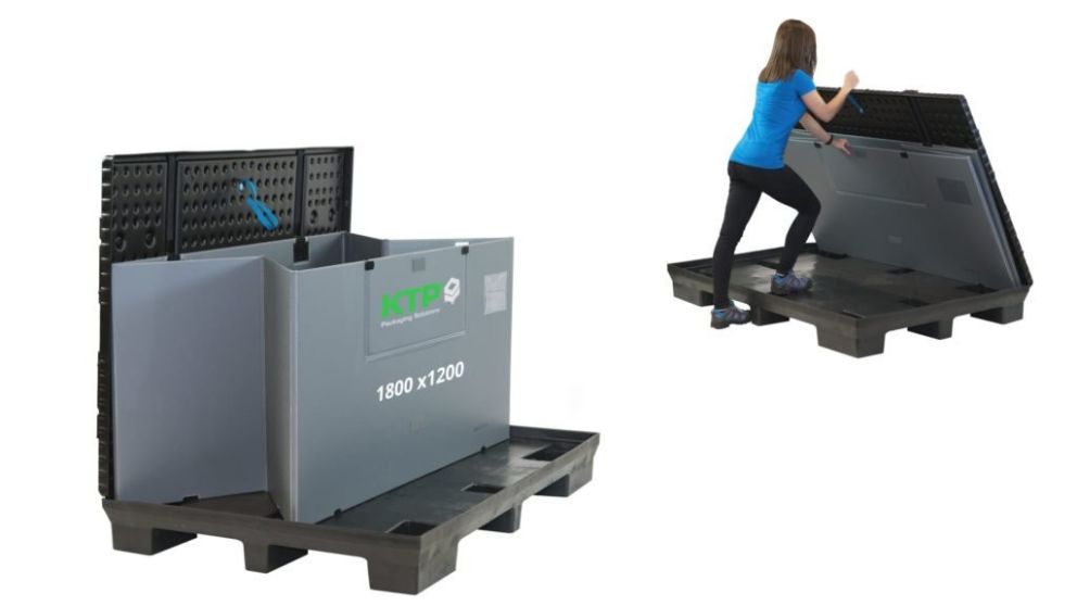 A person in a blue shirt is assembling a large plastic storage container on a black pallet, with part of the container open and leaning against it.