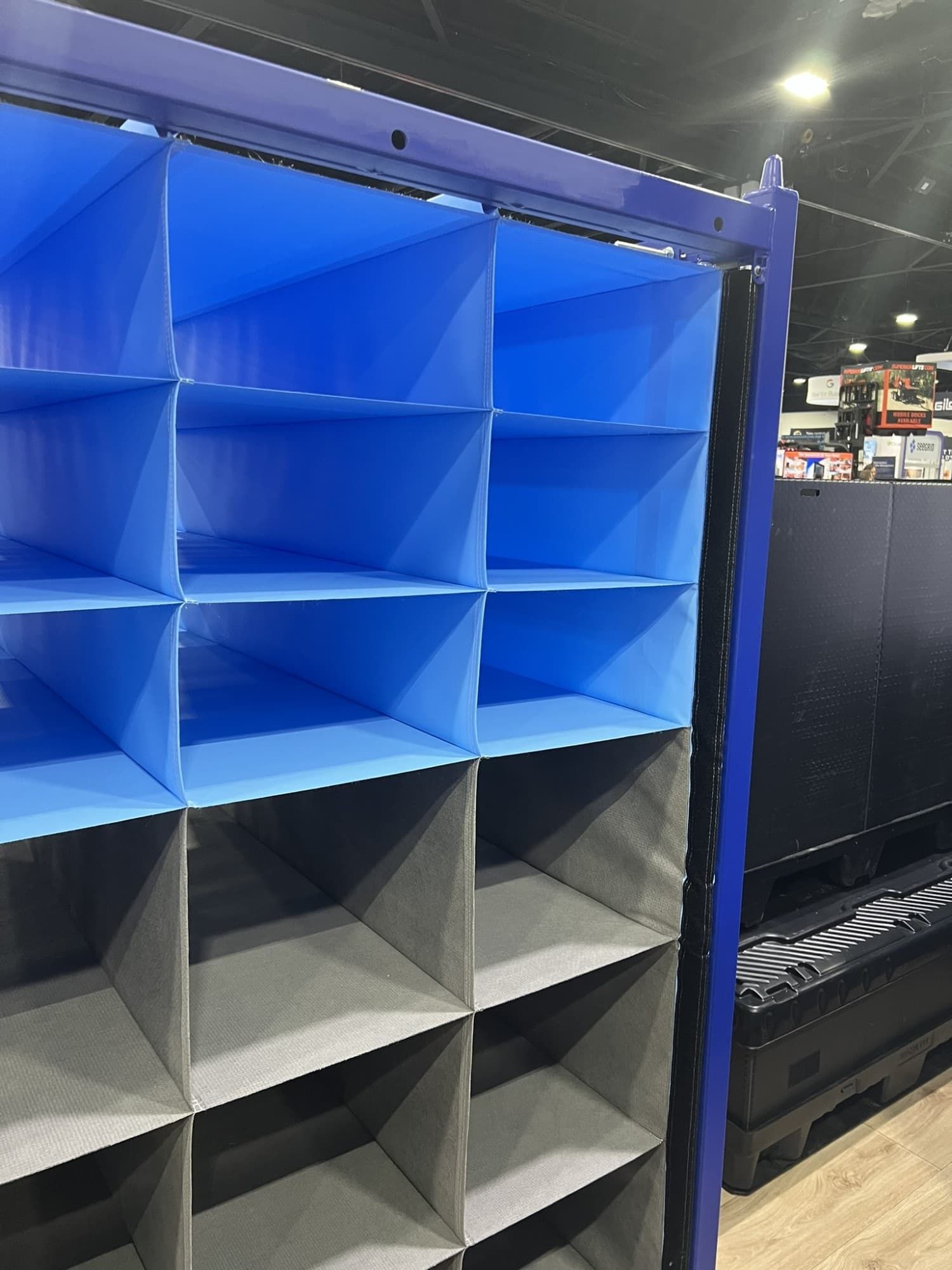 A close-up view of a blue and gray storage organizer with multiple compartments, set in a retail environment.