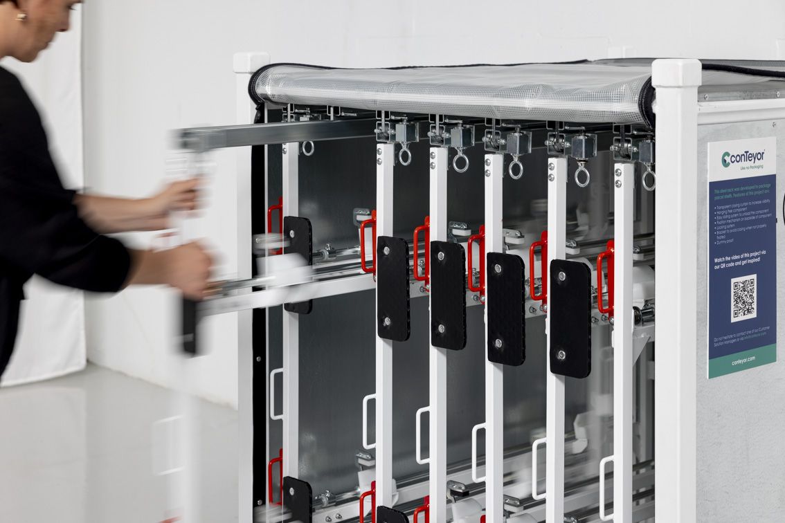 A close-up of a person pulling out a fitting from a steel rack