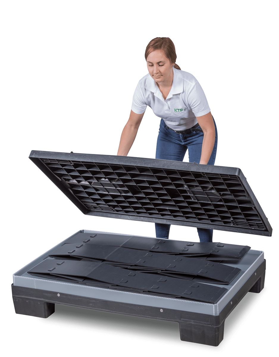A woman in a white shirt is lifting the cover of a black transport platform, revealing interlocking panels inside.
