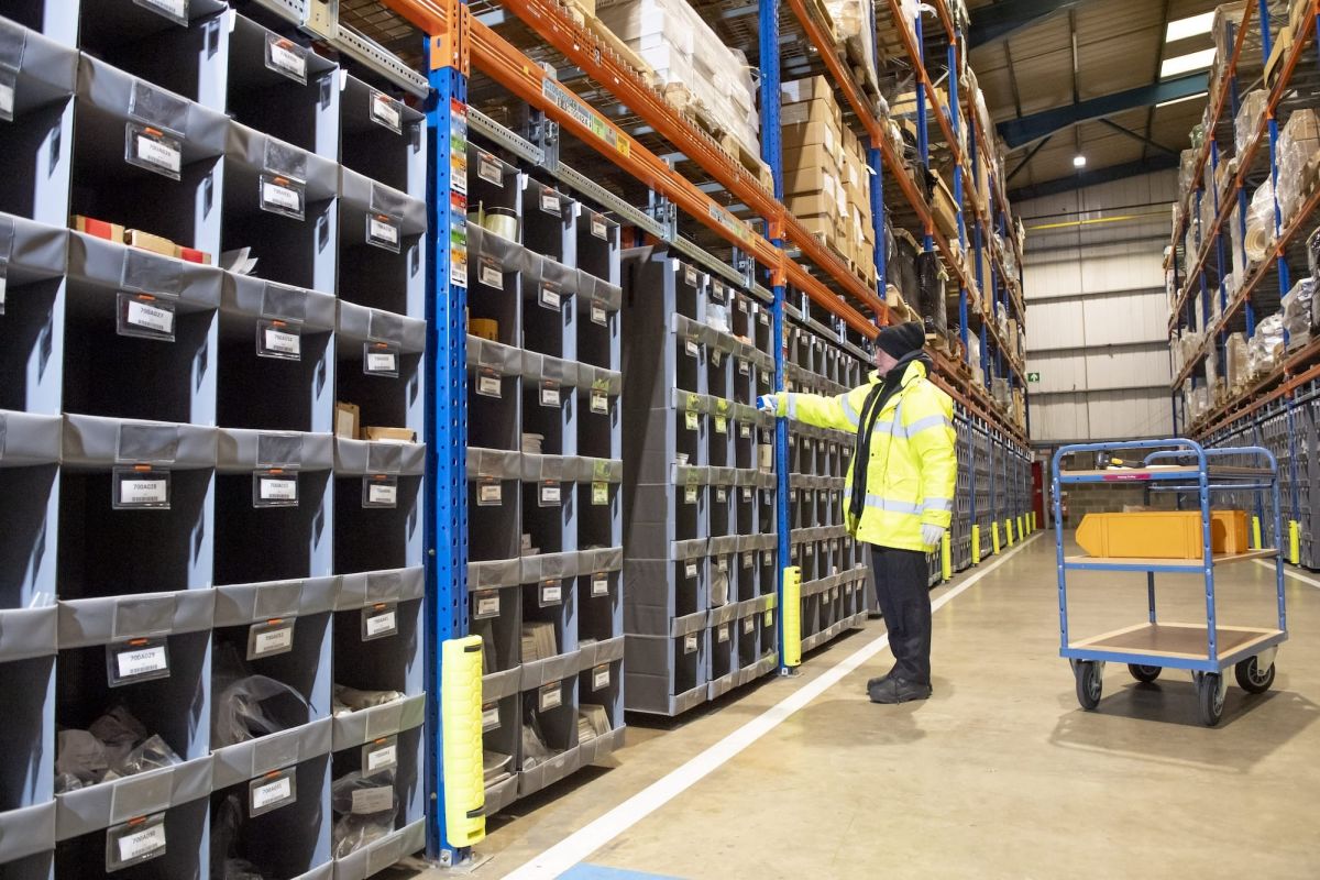 A man in a yellow jacket operating a Storeganizer installation
