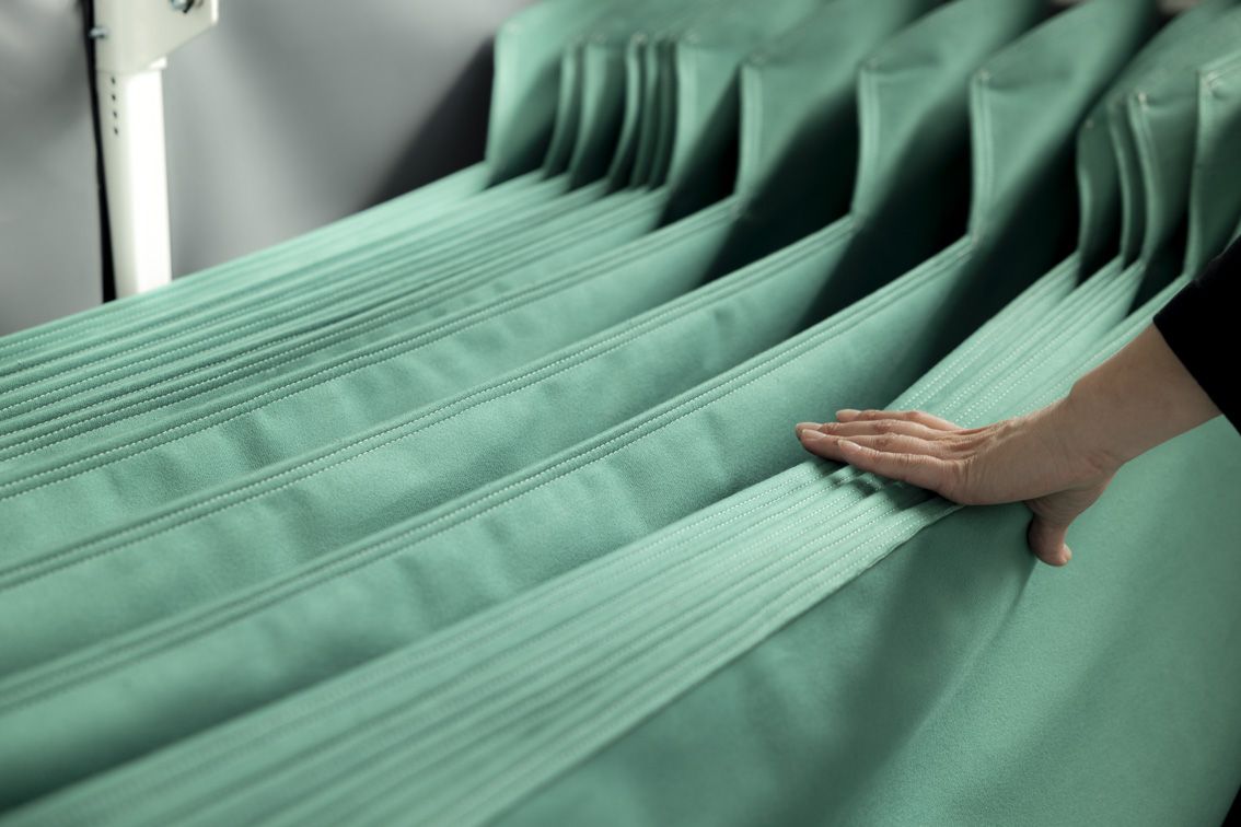 Green textile custom dunnage inserts with a hand holding them