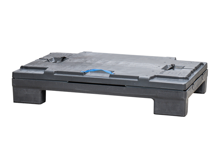 A black plastic pallet with a blue strap on top, resting on a concrete floor.