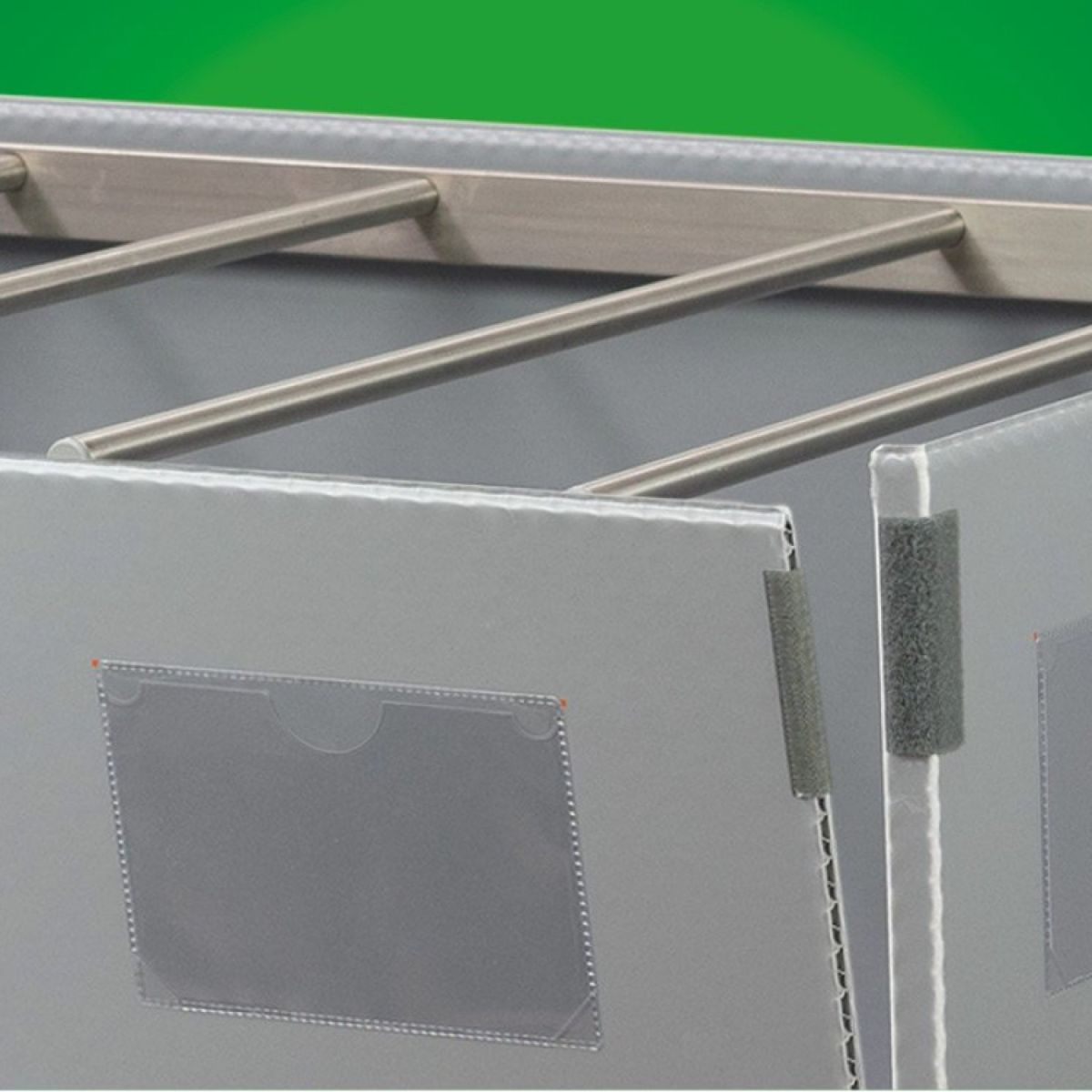 Close-up of a grey storage container with metal rods, featuring clear plastic pockets on the sides for labeling or documentation.