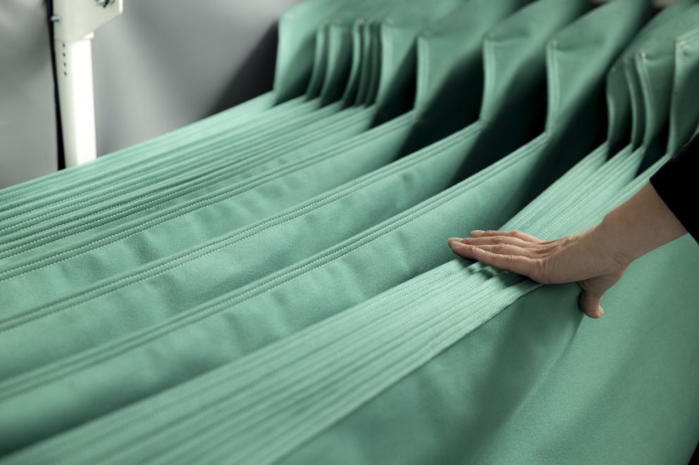 Green textile custom dunnage inserts with a hand holding them