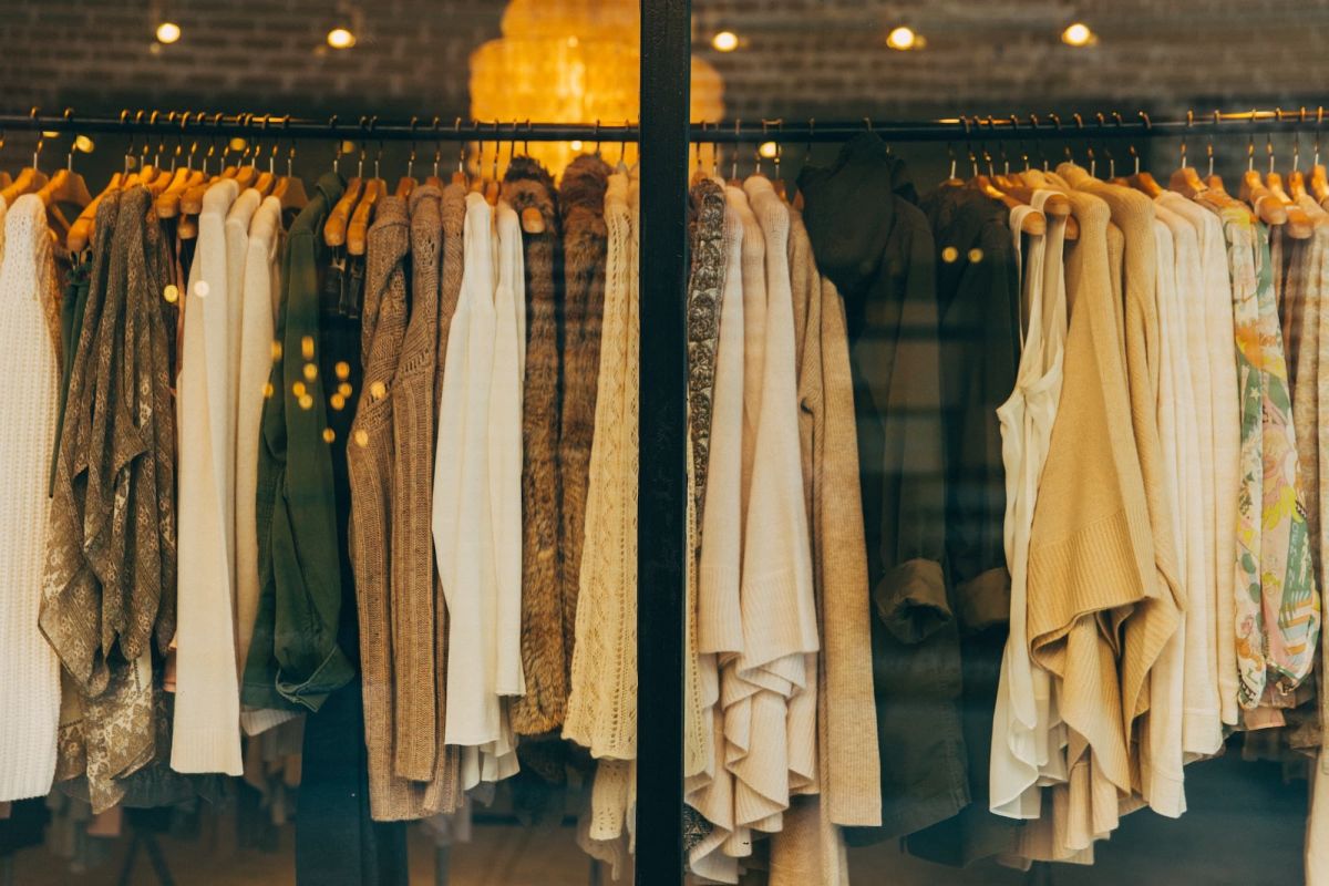 A rack of fancy clothing behind a store window
