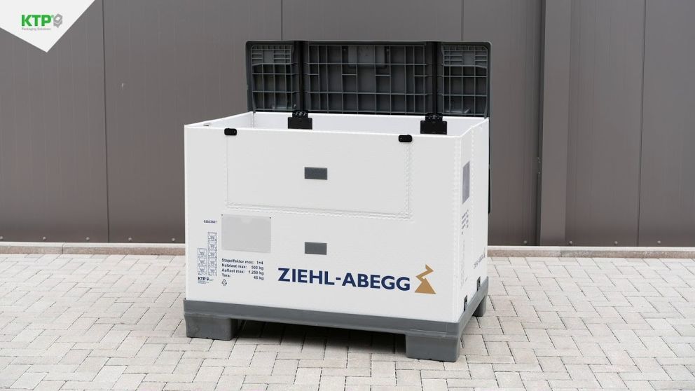 A white industrial container with a black top, featuring the logo "ZIEHL-ABEGG," displayed on a paved surface with a gray wall in the background.