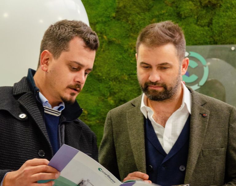 Two people brwosing a conTeyor brochure